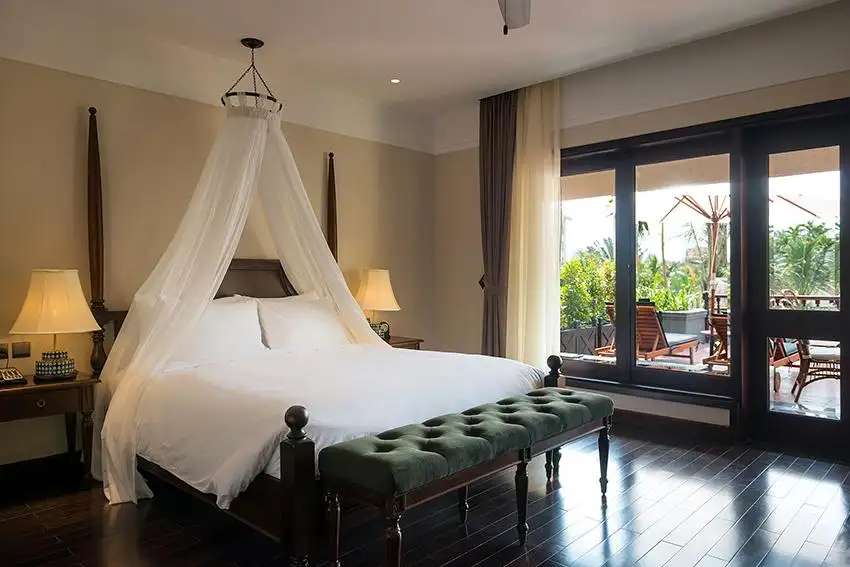Phòng ngủ với ban công rộng rãi của Premium Suite New Terrace  tại La Siesta Hoi An Resort & Spa