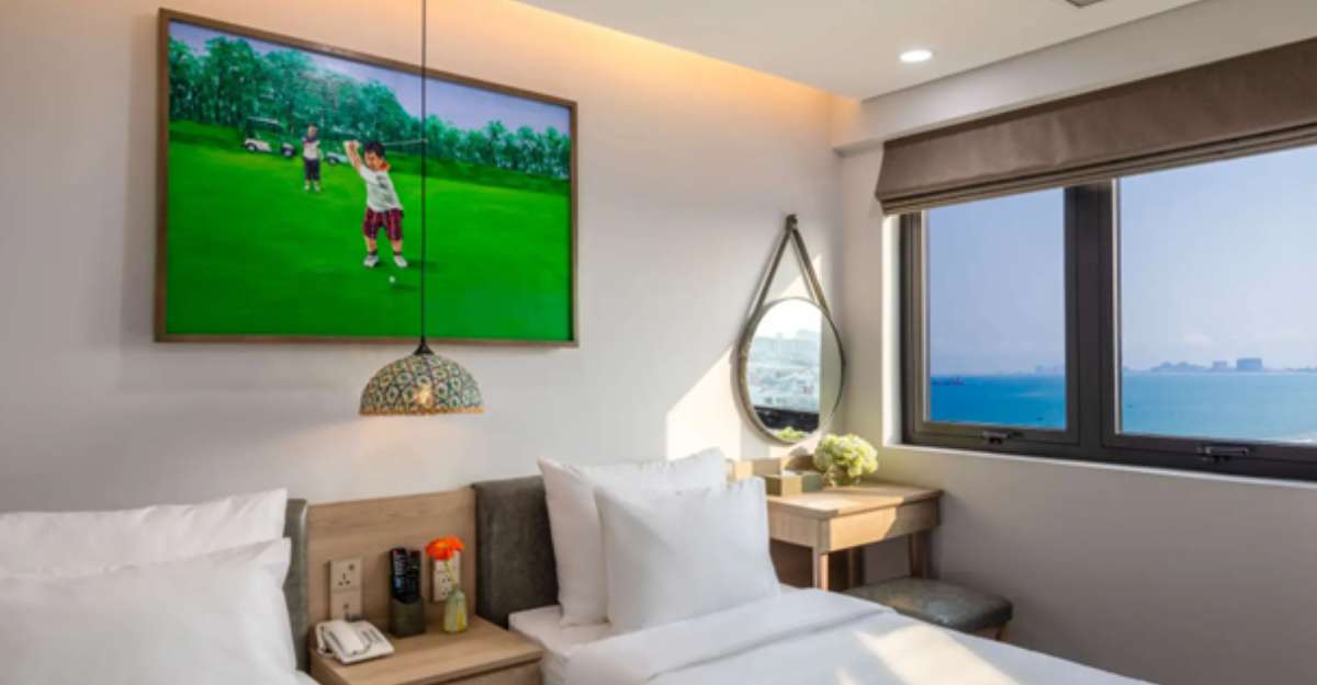 Deluxe Twin Sea View tại Nguyen Gia Hotel đón nắng vàng rực rỡ từ khung cửa sổ nhìn thẳng ra biển