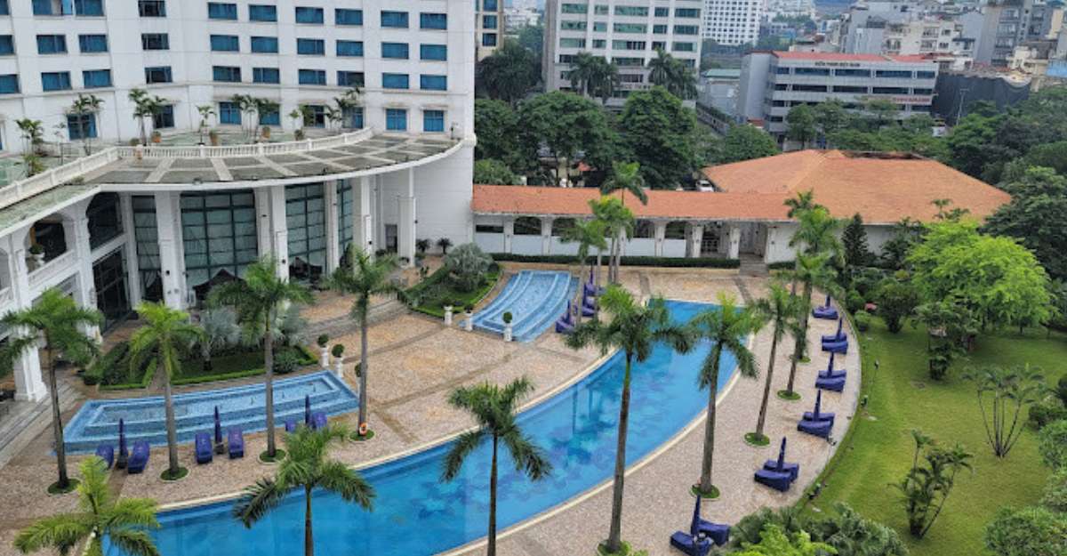 Hồ bơi ngoài trời được bao quanh bởi rặng cây xanh mát