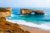 Discover tiny penguins returning to the shore on a beach featuring an arch that was once connected to the mainland until the connecting arch collapsed in the 90s