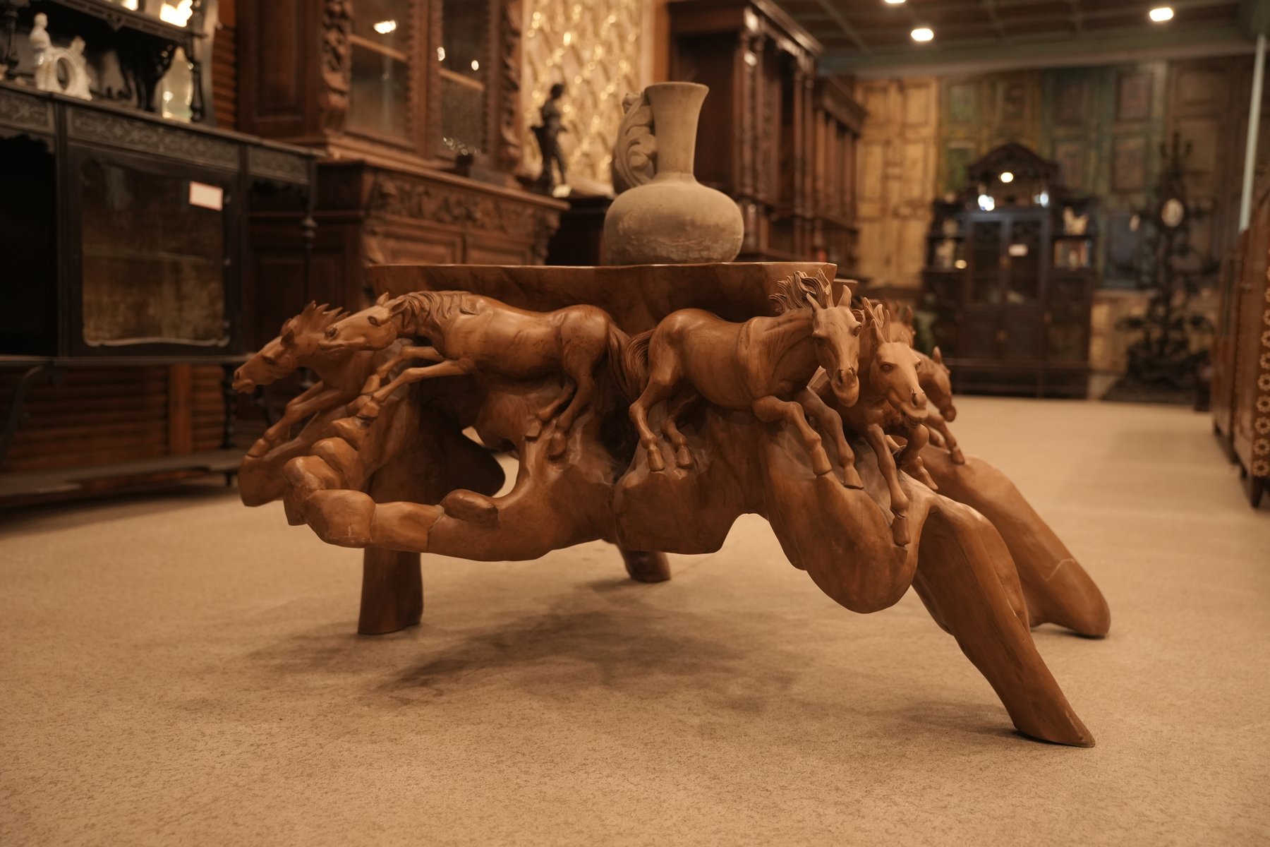 Unique root wood coffee table showcasing intricately hand-carved galloping horses, crafted from a single piece of wood and finished to highlight its natural beauty and character.