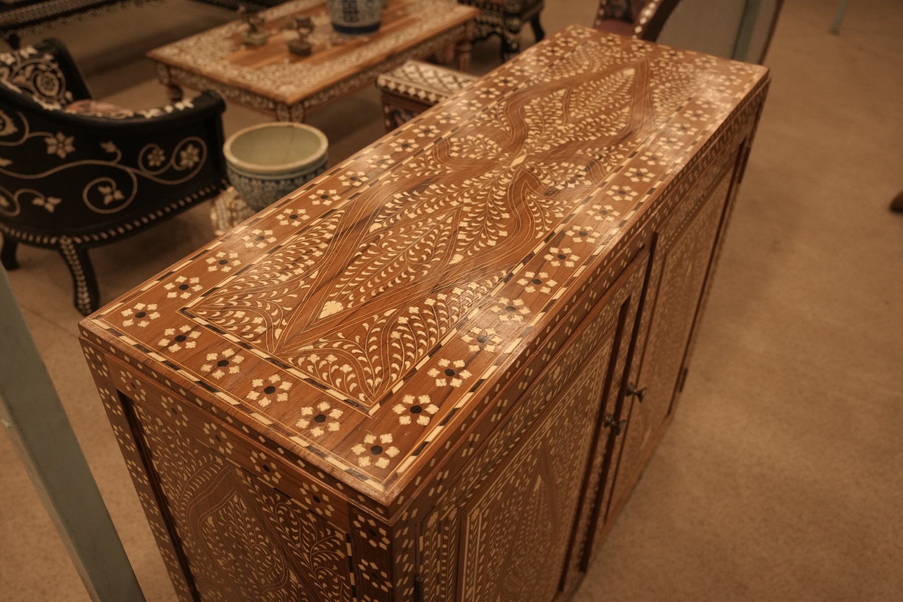 Indian teak wood cabinet featuring intricate bone inlay work in floral and geometric patterns.