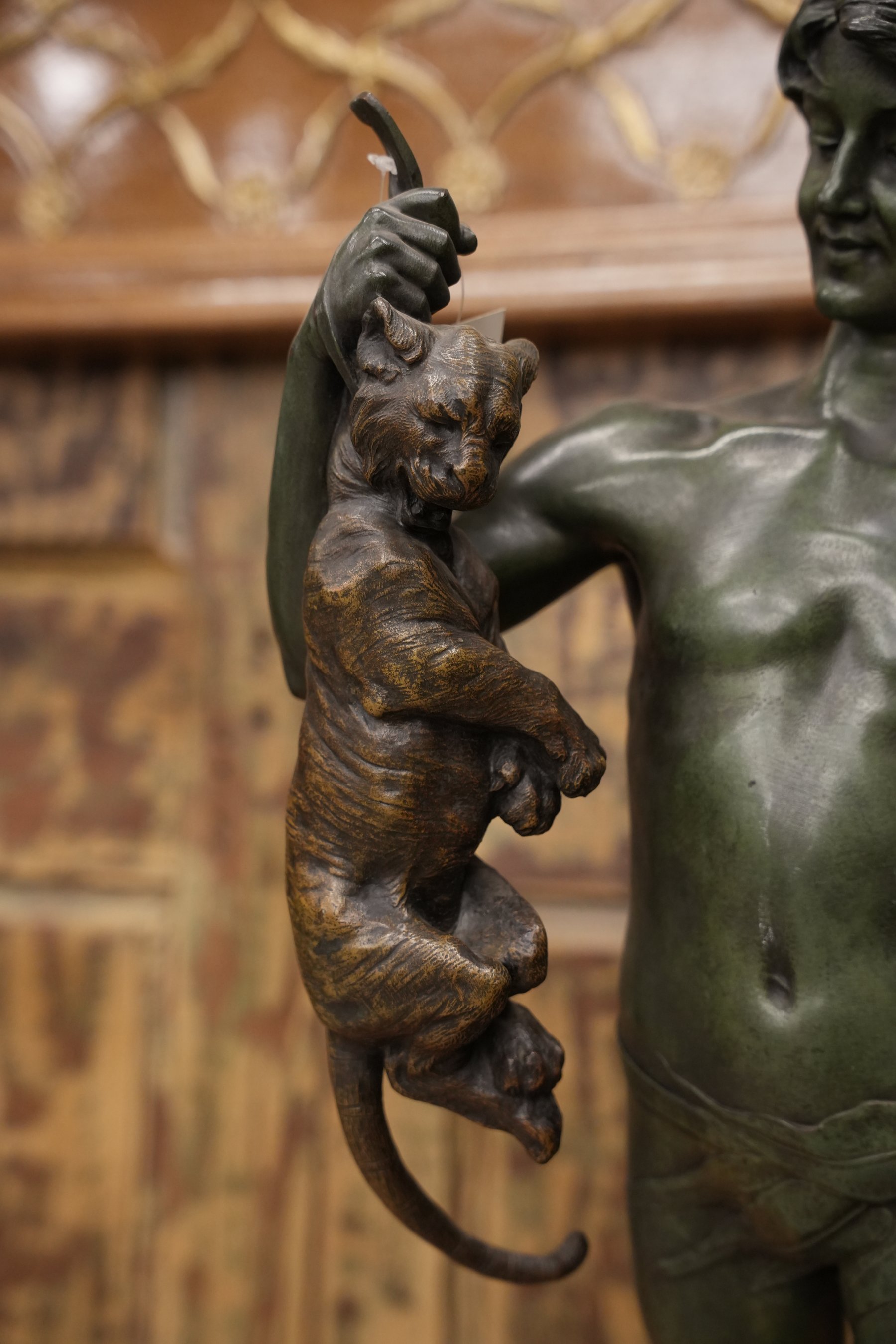 A 19th-century patinated bronze sculpture of a youth and wildcat, blending classical craftsmanship with symbolic elegance and refined detail.