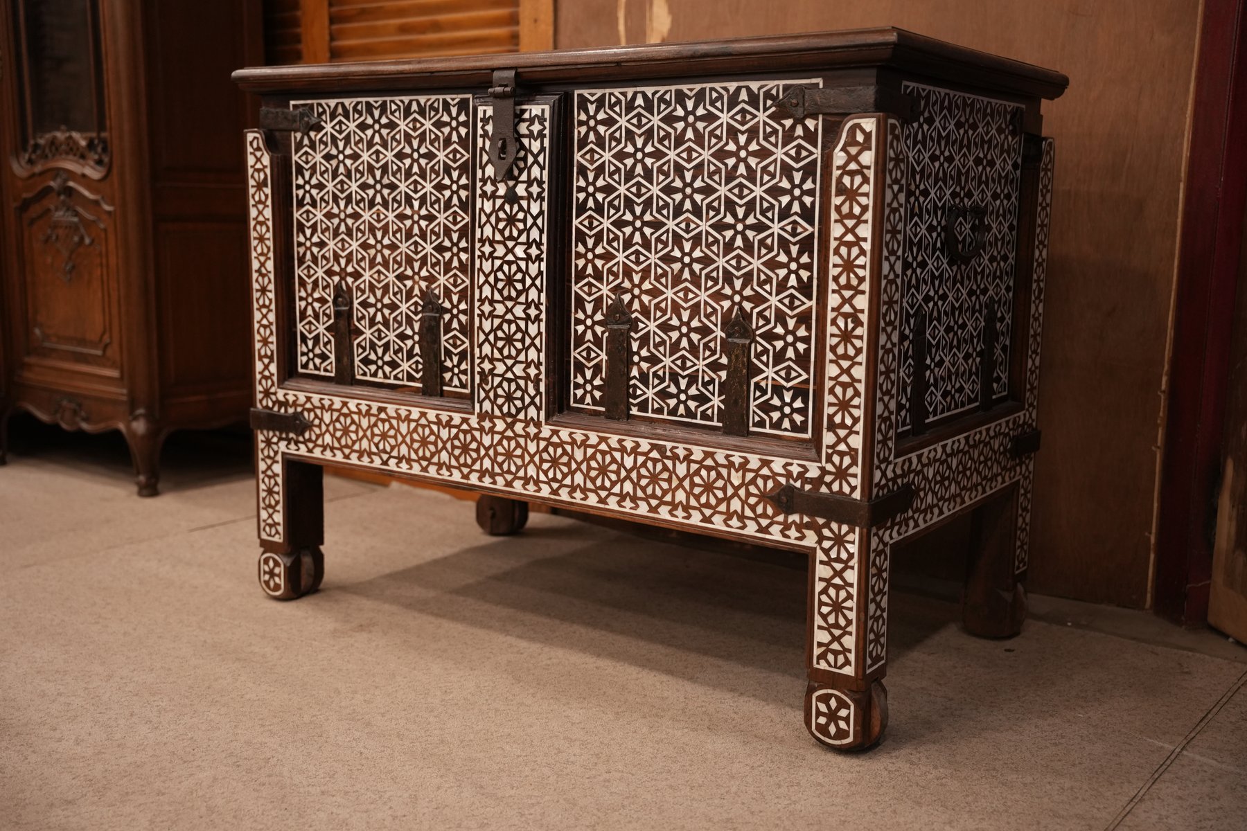 This is an antique wooden chest with intricate geometric inlay work, similar to Syrian or Indian wedding dowry trunks.