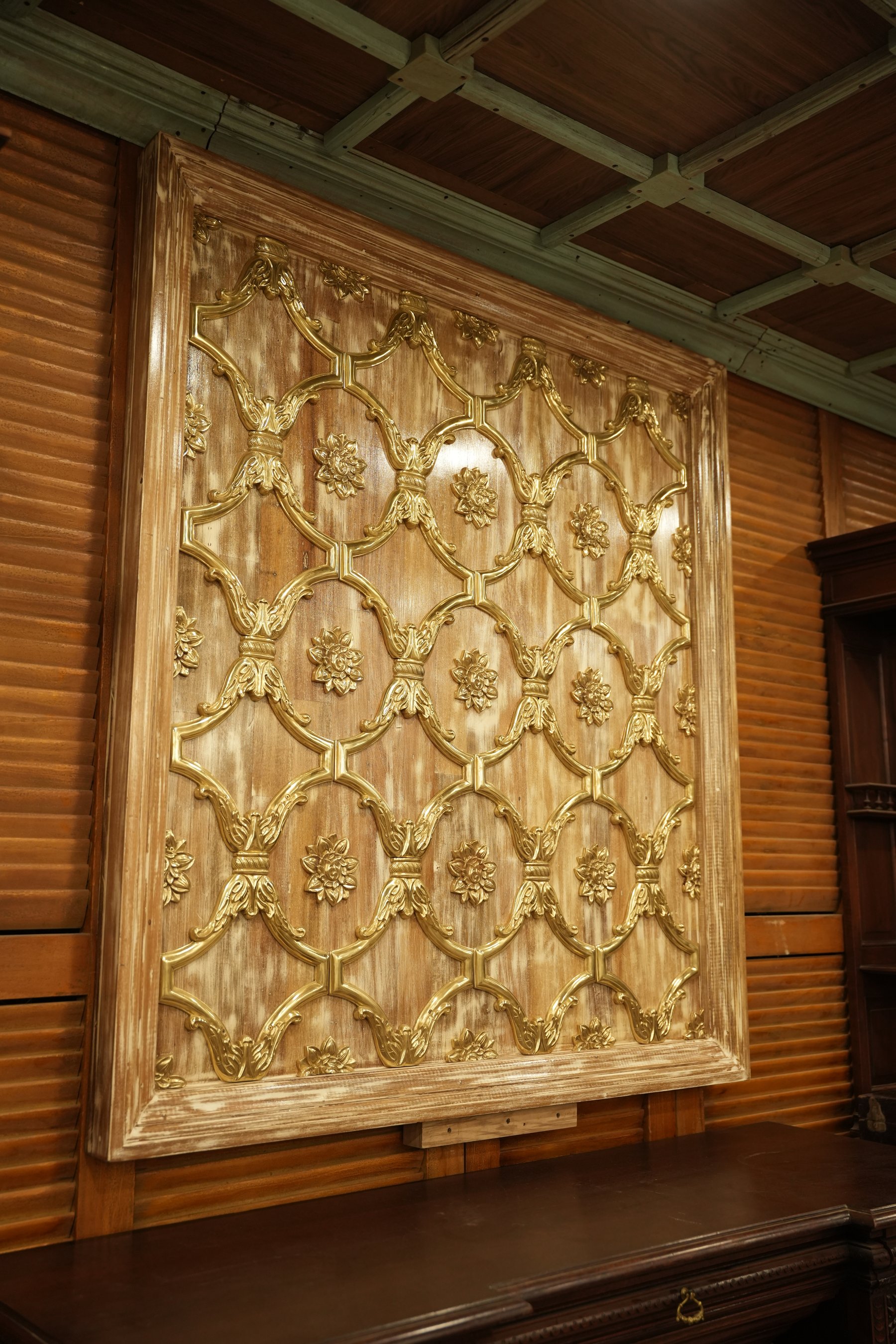 A statement Baroque wall panel with golden brass detailing over textured wood, blending elegance, artistry, and architectural luxury.