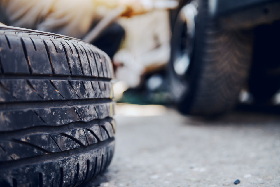 Auto mechanic replacing a worn-out tyre