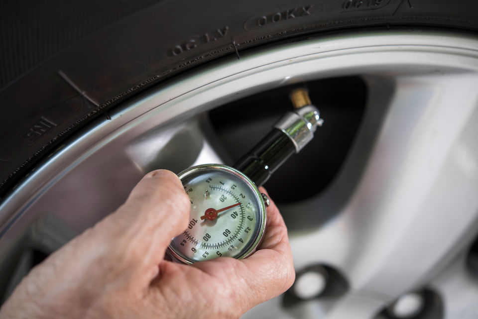 Checking tyre pressure with a gauge