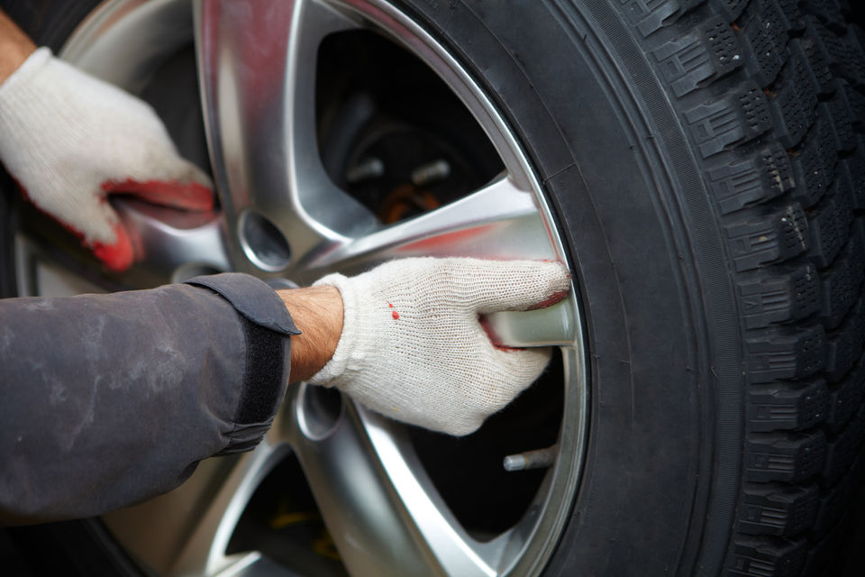Mechanic performing tyre rotation for extended tyre life