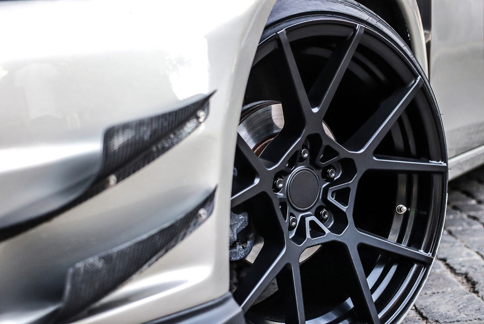 A low profile rubber on a shiny black rim of a sports car