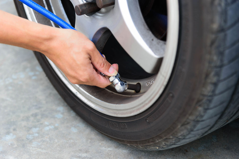 Checking tyre pressure using a gauge provided at a gas station