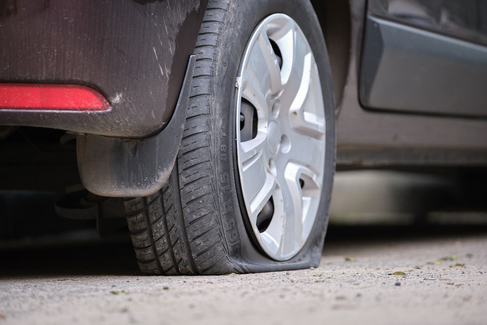 Car with a flat tyre being driven to a repair shop