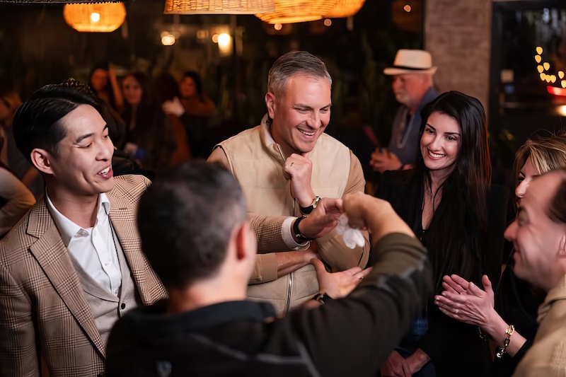 Guests enjoying close-up magic at a Purim party