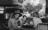 Fotograma de la película.Una chica en una mesa de café con un dispositivo de información portátil