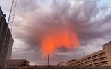 This is a meteorological phenomenon known as Virga, when rain evaporates before reaching the ground. Here it is illuminated by the rays of the setting sun.