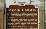 In the 1800s, before naming roads became common practice, intersections were often given names to designate settlements and landmarks.The trail through Brass Ball Corners started at Lake Michigan and went west through Lake Geneva to Janesville. Farmers and traders often walked along the trail, transporting grain, furs and lead to the port of Kenosha.In 1842, farmer Seth Huntoon realized the growing need for a place where travelers could relax. He built a hotel on the northwest corner of a busy intersection, and then hung a gilded wooden ball at the intersection. Because of its resemblance to brass, the intersection became known as Brass Ball Corners.Over time, the corners grew, as a school, a post office, a church, a shoemaker and several houses were built on the corner. The community eventually became the village of Paddock Lake. Today, a replica of a brass ball hangs nearby. Installed in 2005 by the Wisconsin Historical Society.