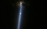 Самолёт, летящий в свете прожектора на церемонии памяти жертв терракта в Нью-Йорке
