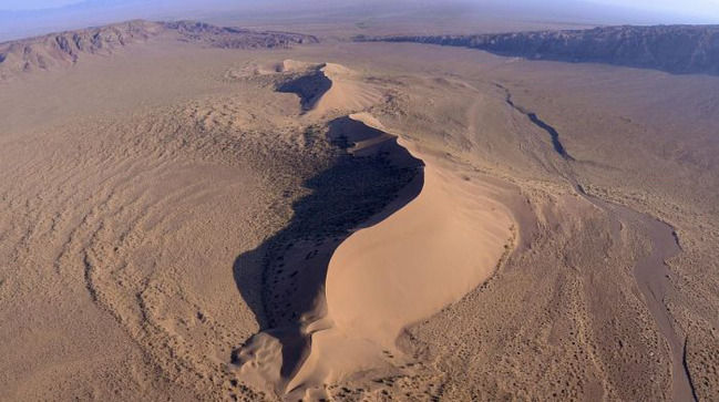 Accum-Kalkan

This sand dune with a length of over 3 km and a height of about 200 m is called "Singing mountain". It is located in the Park Altyn-Emel, in the Dzungarian Alatau. The mountain actually "sings": when the wind is strong, it "howls", "screaming" or making a sound like the rising hum of a jet engine.

The legend says that this mound, which serves as a burial place for the remains of some eminent person. There is even a version that is Genghis Khan himself, as the grave of the great conqueror is still not found.

Another local legend claims that this hill once hid from the wrath of Allah Shaytan. Once inside, he fell asleep and the howls because he dreams.

The researchers think that the dune was formed from sand that is struck by the wind from shallows of the ili river. And the reason is "singing" - the movement crumbling and rubbing together of sand grains.
Translated by «Yandex.Translator»