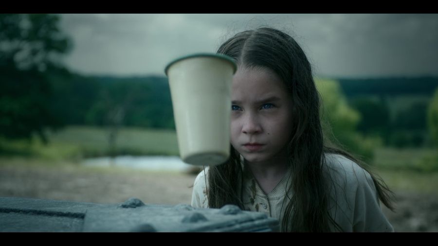 Matilda lifts a plastic cup into the air with the power of her mind