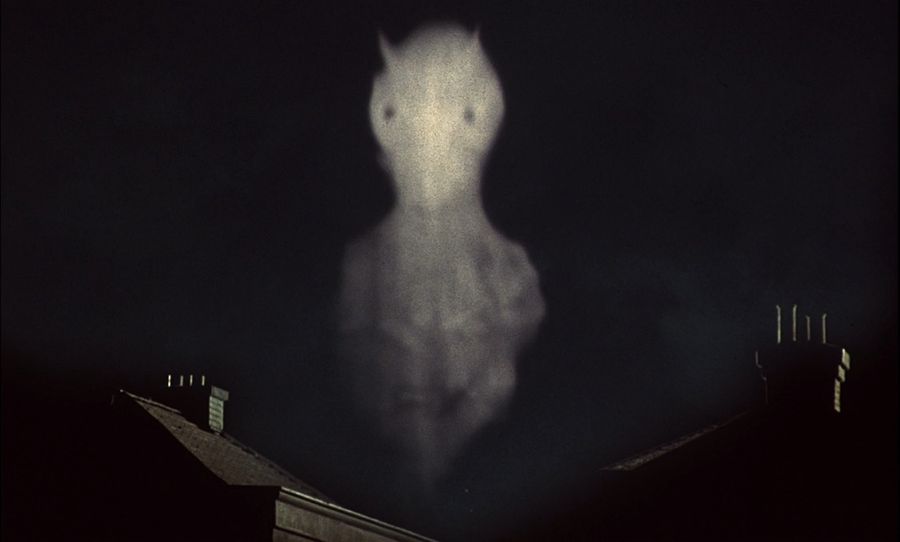 Projection of an image of an alien's head in the sky over London