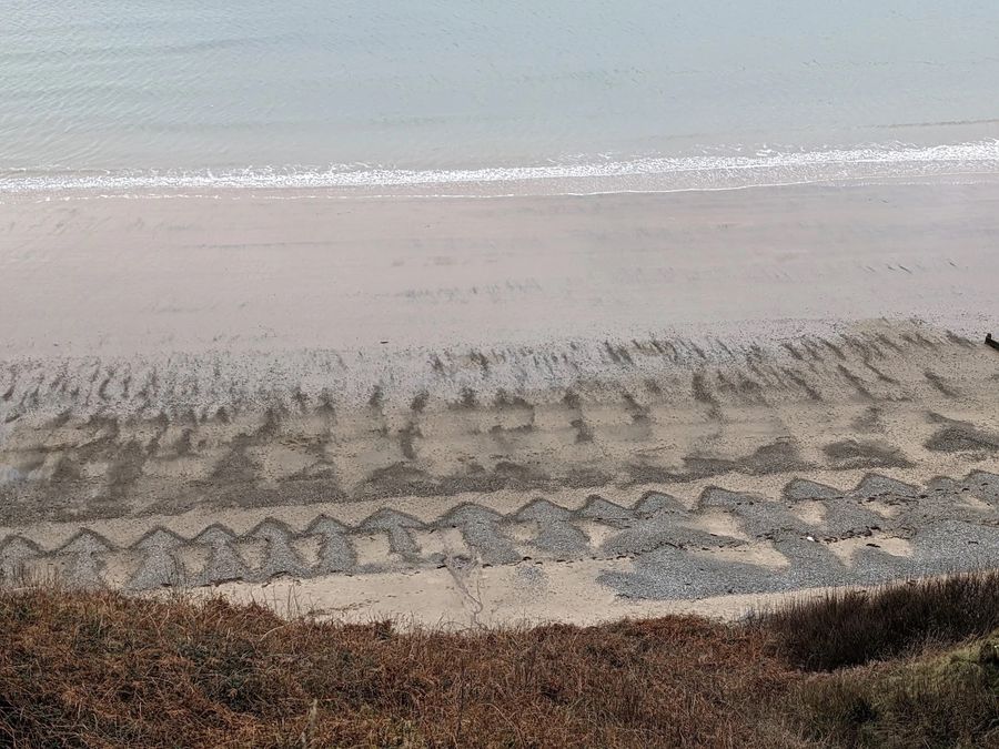 The waves made the piles of stones look like arrows