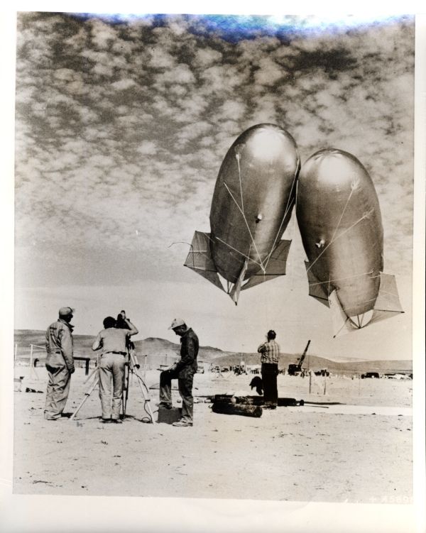 Lanzamiento de sondas meteorológicas antes de las pruebas nucleares en la base de la fuerza aérea de Indian Springs (Nevada) el 14 de marzo de 1953.Estos globos Keaton llenos de helio se utilizan para obtener información sobre la presión, la temperatura y la humedad del aire, así como otros datos meteorológicos durante los períodos de prueba atómica en el sitio de prueba de Nevada. Se envían al aire antes de cada prueba nuclear y descienden unos minutos antes de la explosión real.Por lo tanto, la información meteorológica de último minuto se transmite desde la base de la fuerza aérea de Indian Springs al jefe de pruebas de la Comisión de energía atómica en el punto de control. Dichos datos se utilizan para predecir nuevas rutas de propagación de nubes radiactivas en la atmósfera . "