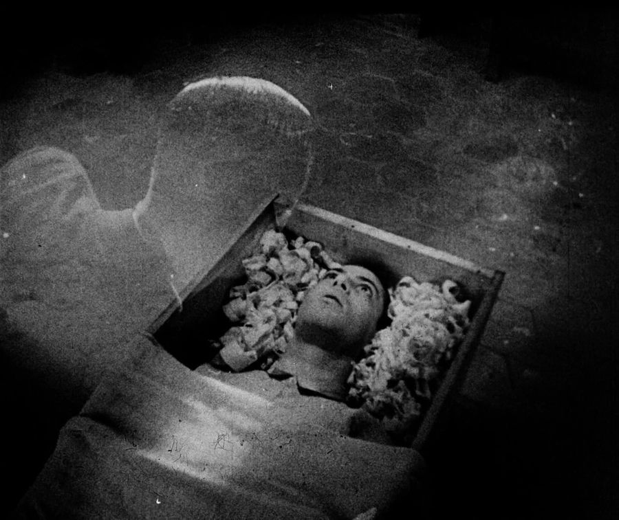 The spirit of Allen gray looks at his body in a coffin