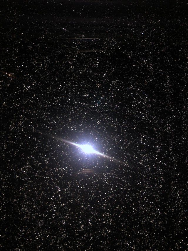 The man took a picture of the window with raindrops. It looks like a planet surrounded by millions of stars.