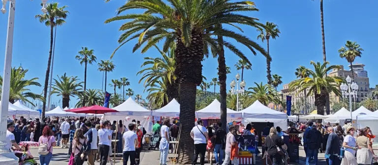 Gente paseando entre los stands del festival en el Moll de la Fusta