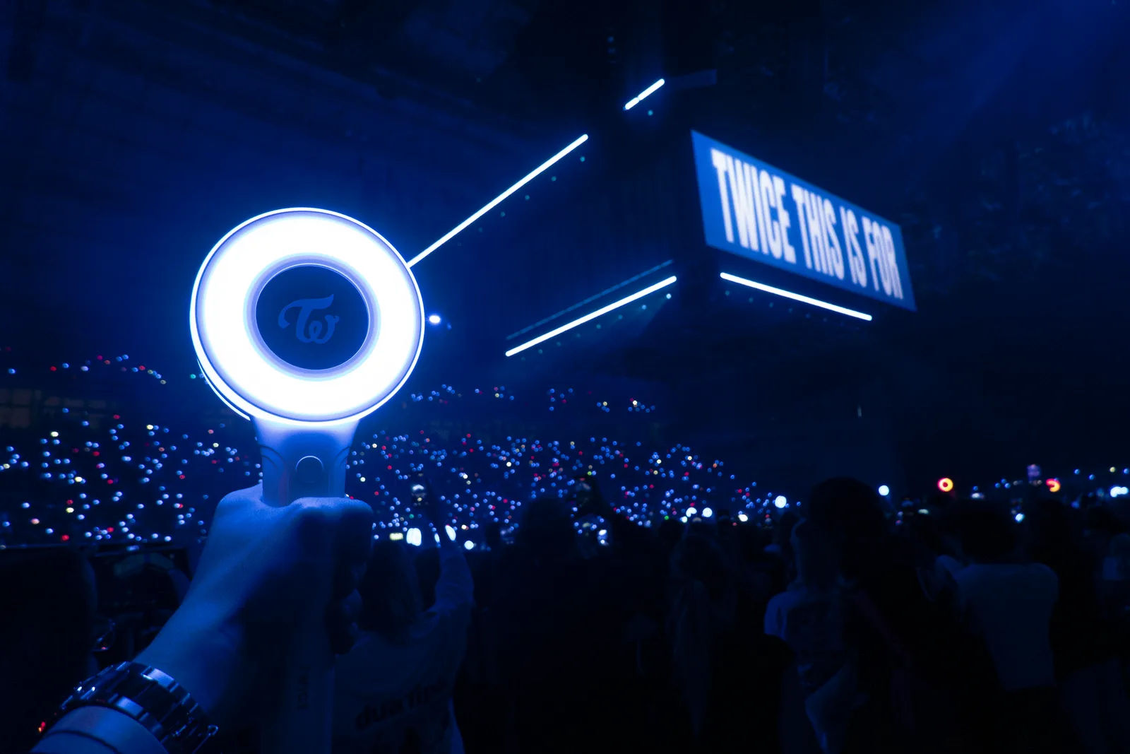Lightsticks y escenario principal dando luz en un Palau Sant Jordi a oscuras