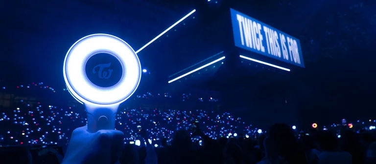 Lightsticks y escenario principal dando luz en un Palau Sant Jordi a oscuras