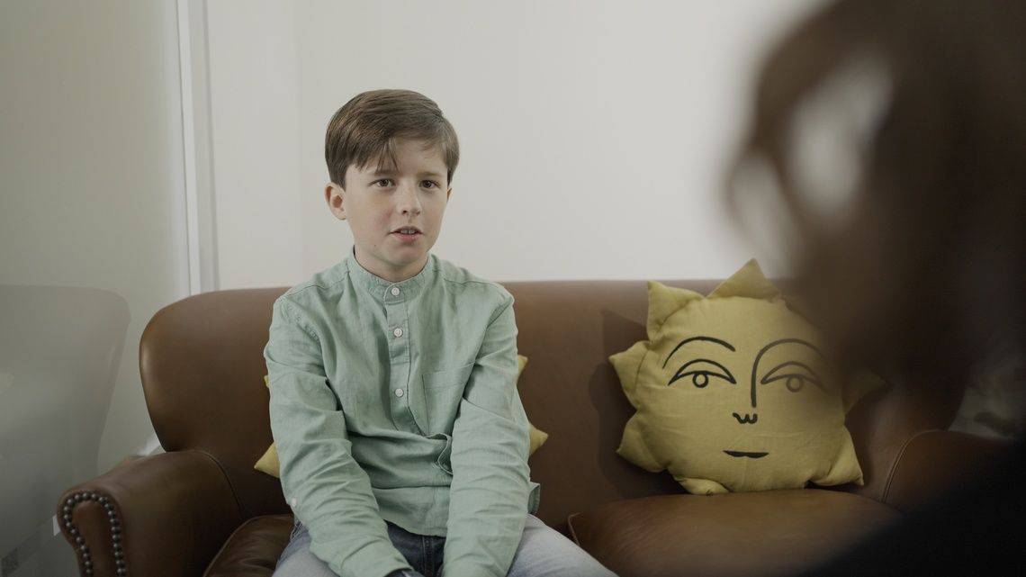 Child seated in the Affiniti+ child therapy room during a session.