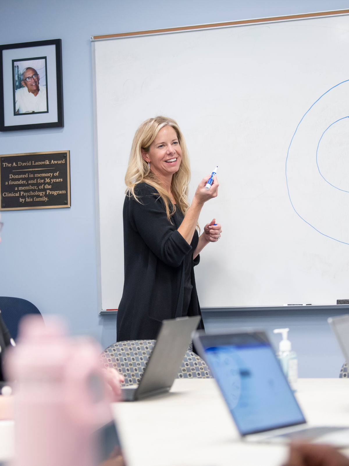 A professor smiling while leading a class in a clinical classroom.
