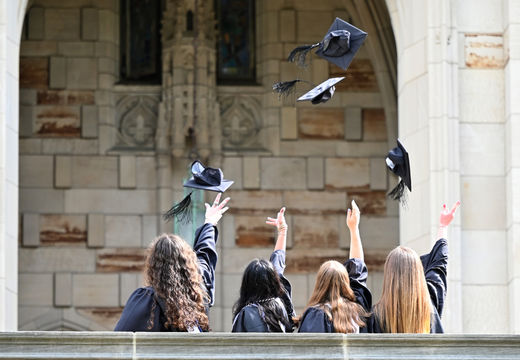 Graduates tossing their caps in front of the Cathedral of Learning.