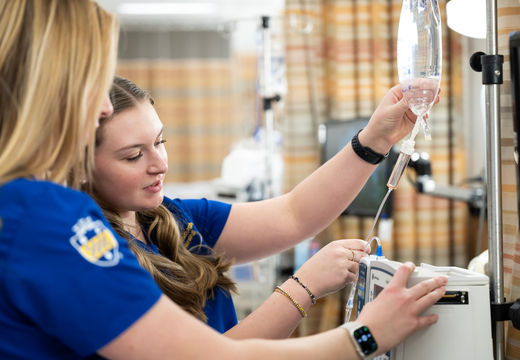University of Pittsburgh nursing students practicing IV setup in a clinical training setting.