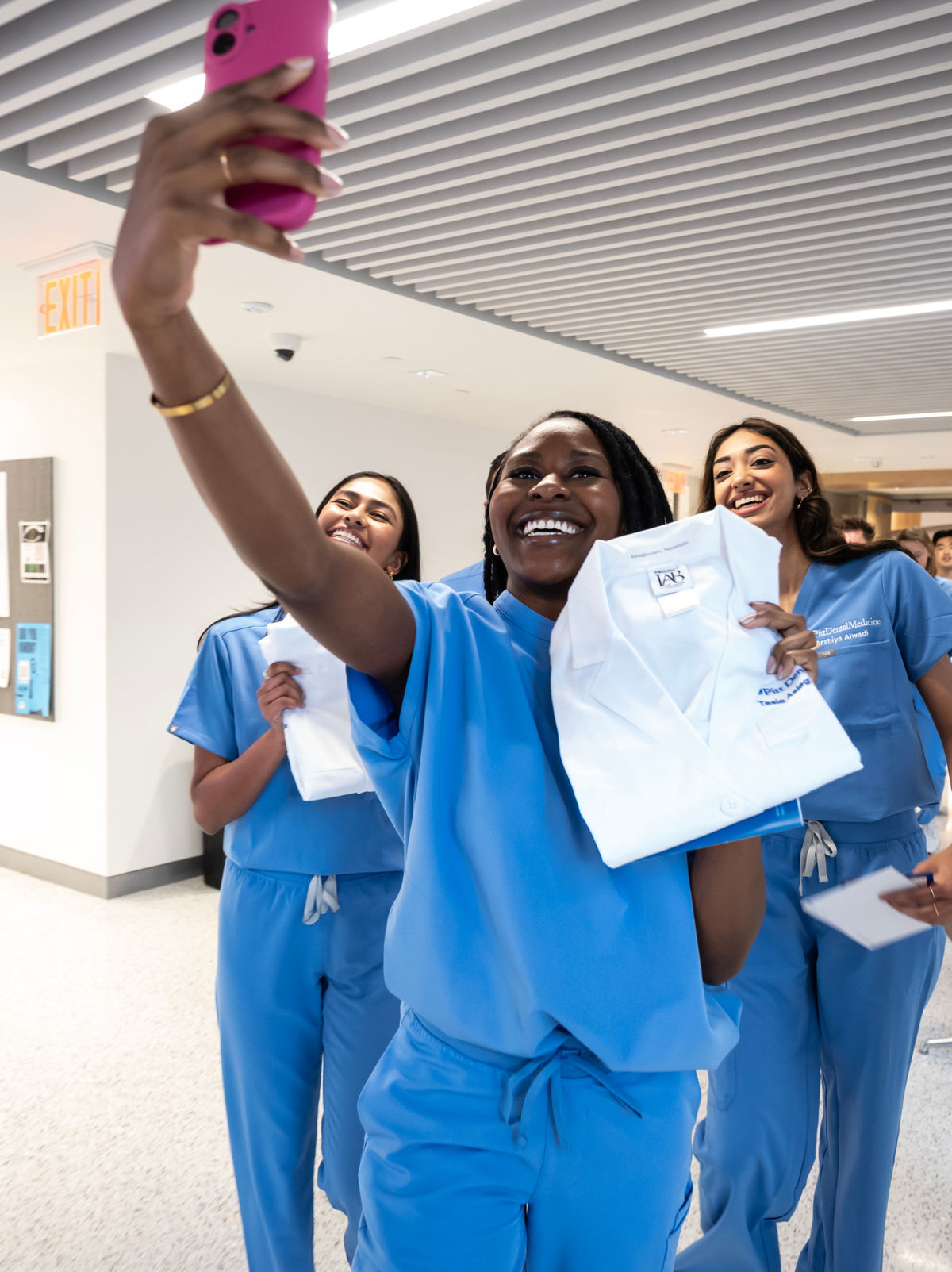 Pitt dental medicine students celebrating and taking a selfie after receiving their white coats.