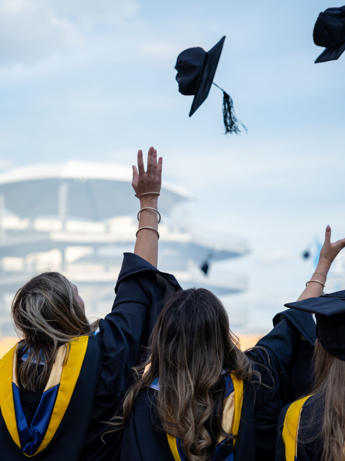 Graduates tossing their caps in the air during a commencement celebration.