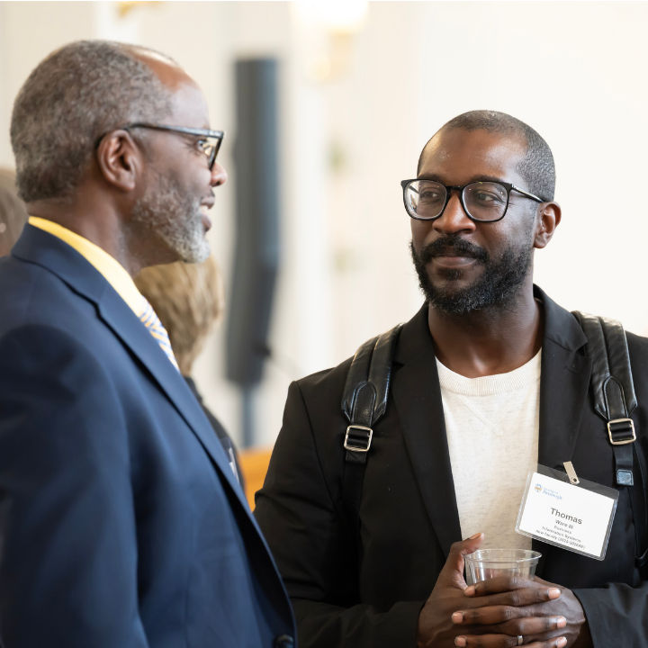 Two people in conversation at a university event.