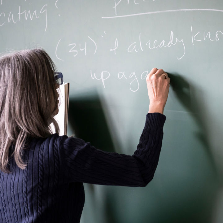 An instructor writing on a chalkboard.
