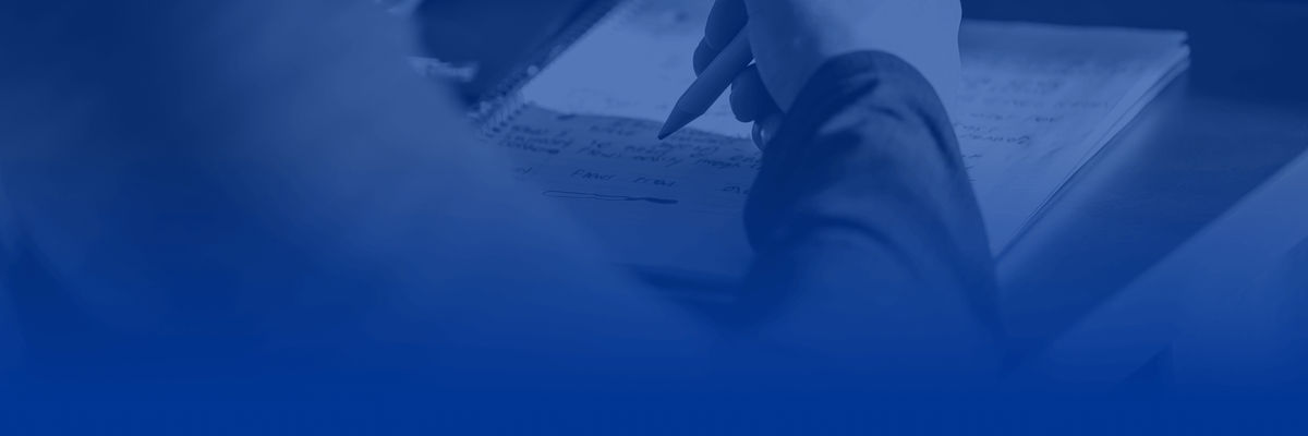 A person writing notes on a desk.