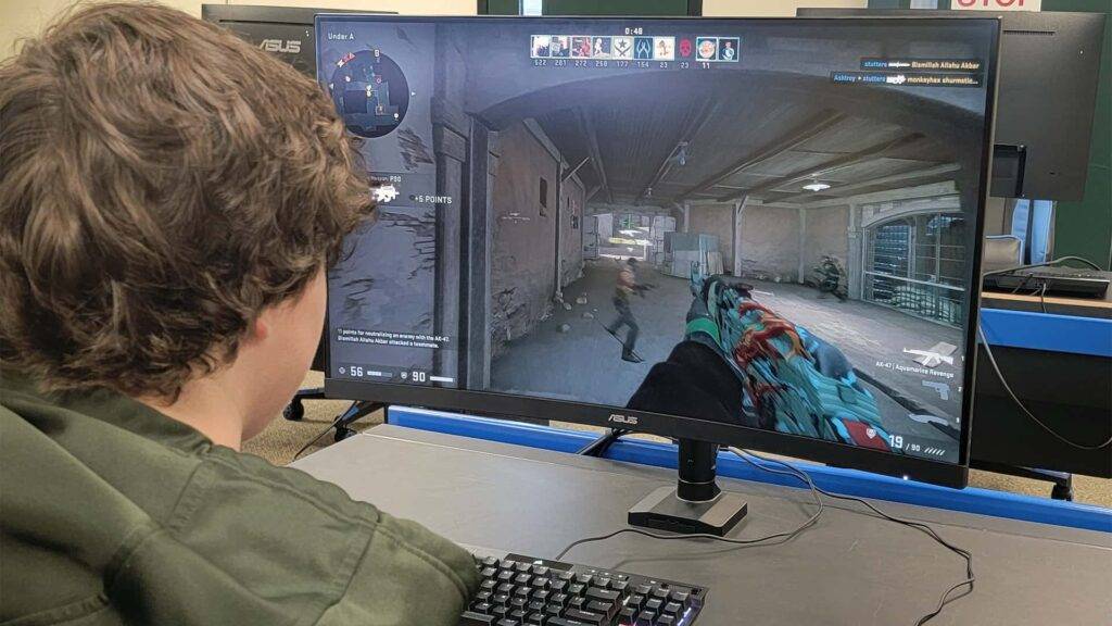 a student playing a first-person shooting game in the eSports center