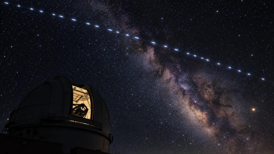 A train of bright satellites crossing the Milky Way above an observatory dome