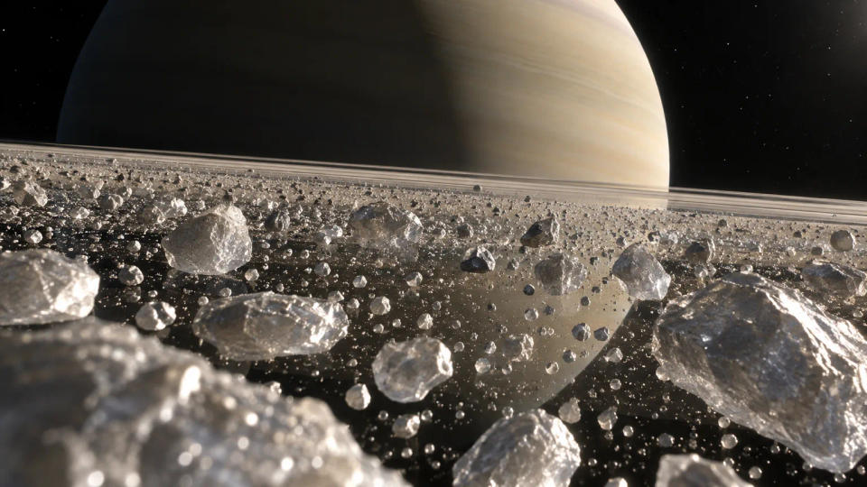 Close view from within Saturn's rings showing countless icy particles orbiting in a very thin plane with Saturn in the background