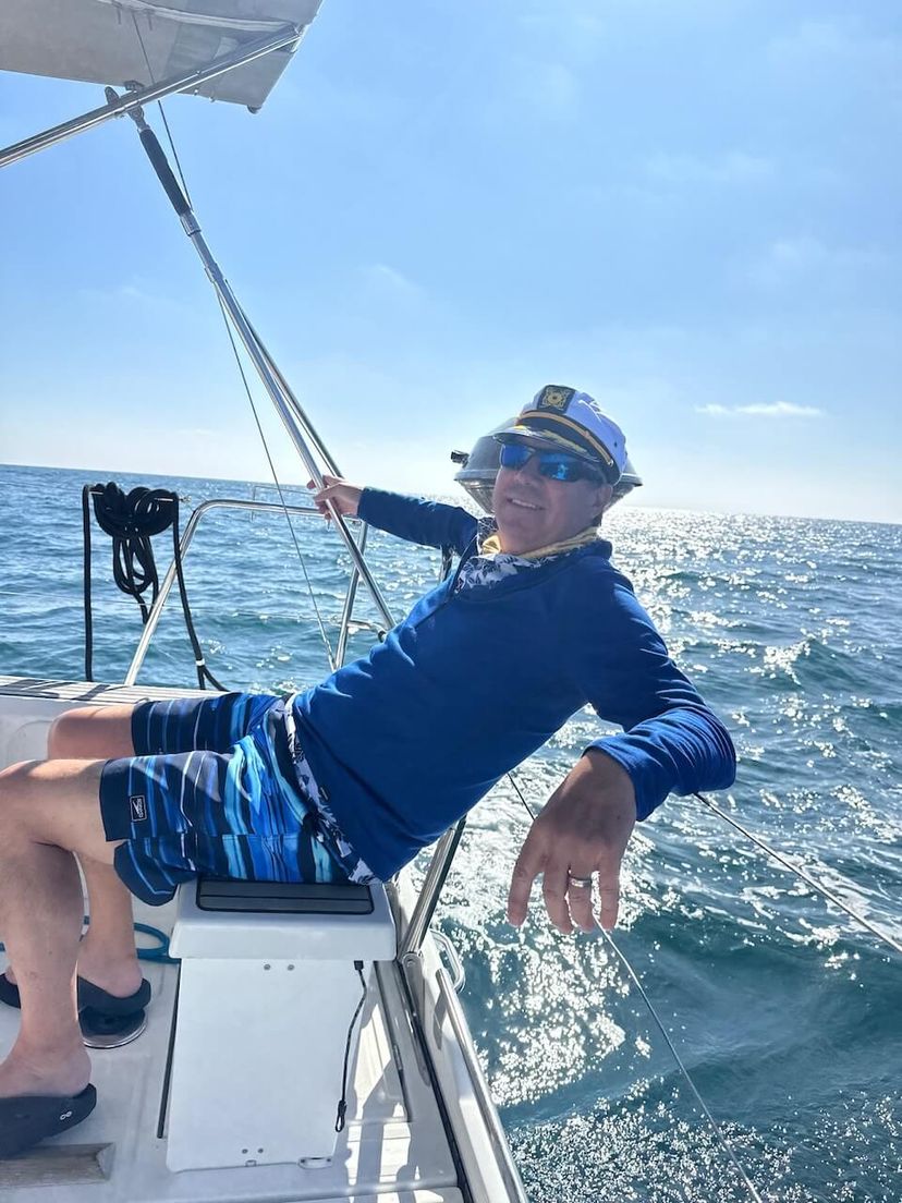 Man relaxing at the helm of a boat during a private boat charter Man relaxing at the helm of a boat during a private boat charter