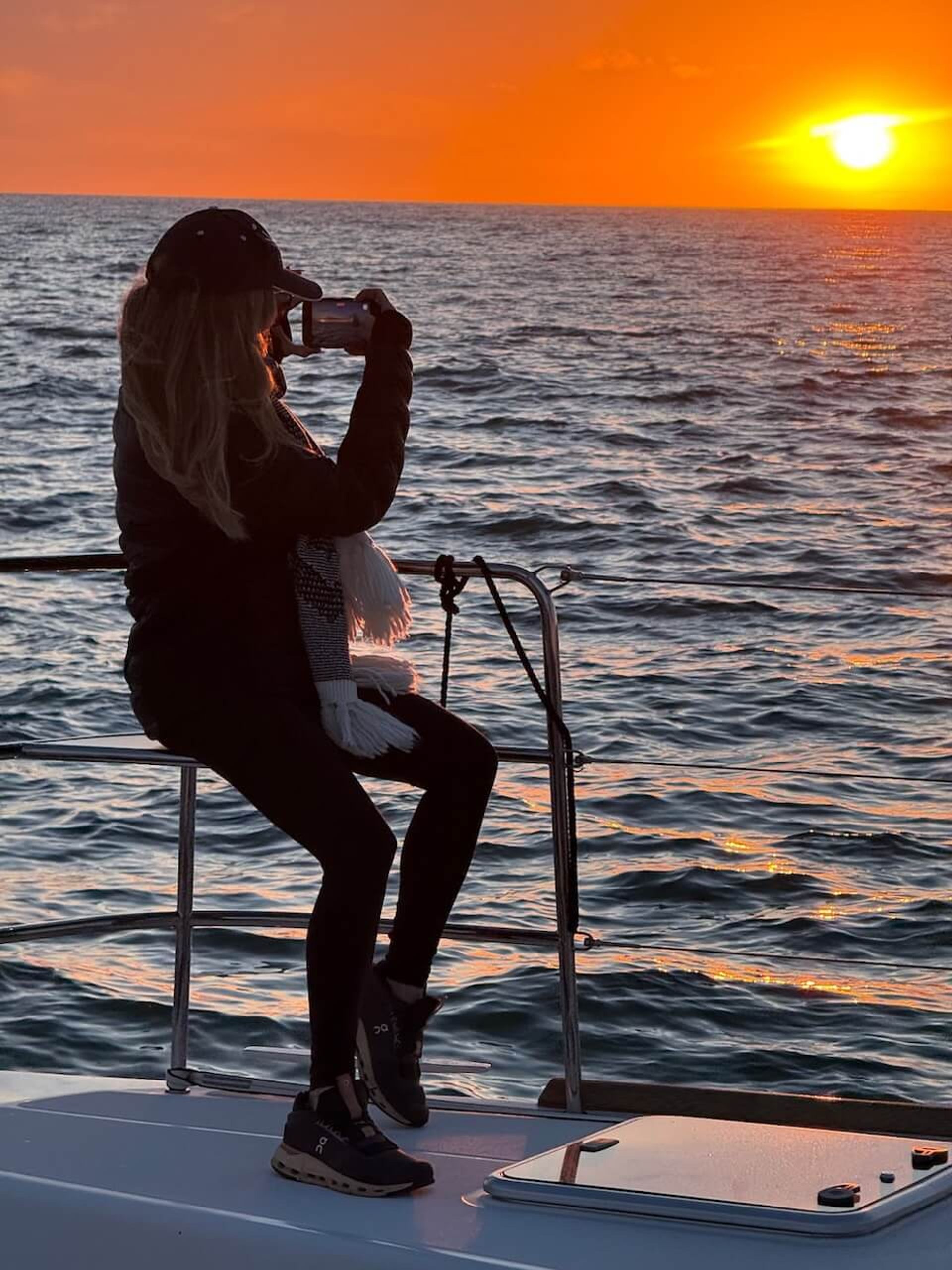Woman taking a picture of the sunset during a sunset cruise in Marina del Rey Woman taking a picture of the sunset during a sunset cruise in Marina del Rey