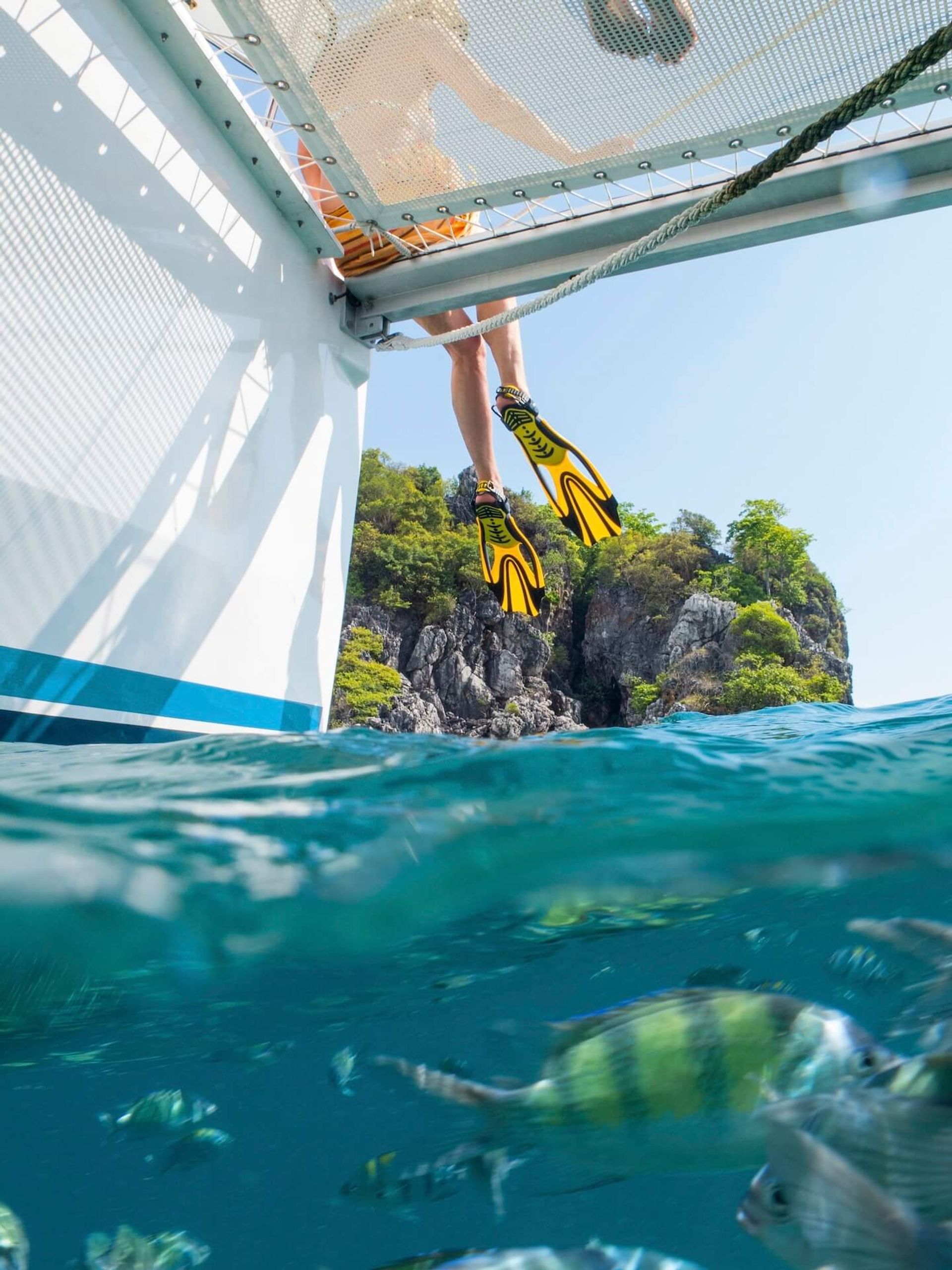 legs of woman dangling from yacht