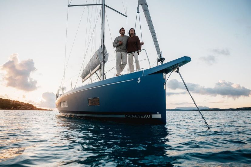 Beneteau Oceanis 47 anchored, side view with guests relaxing on deck. Beneteau Oceanis 47 anchored, side view with guests relaxing on deck.