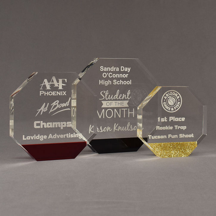 Three ColorCast™ Octagon Acrylic Awards grouped showing red transparent, black and gold glitter accent color options.