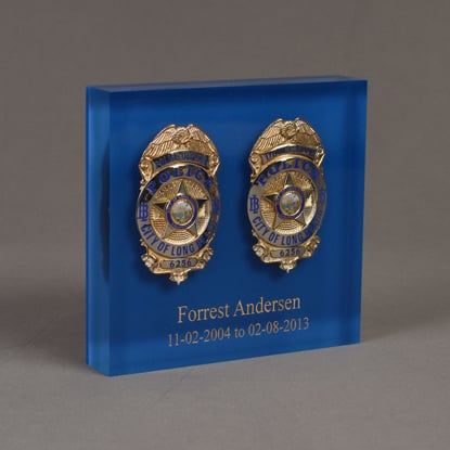Angle view of Lucite® Badge Embedment with police and detective service badges cast inside clear acrylic.