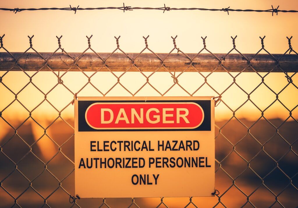 Danger electrical hazard warning sign on fence