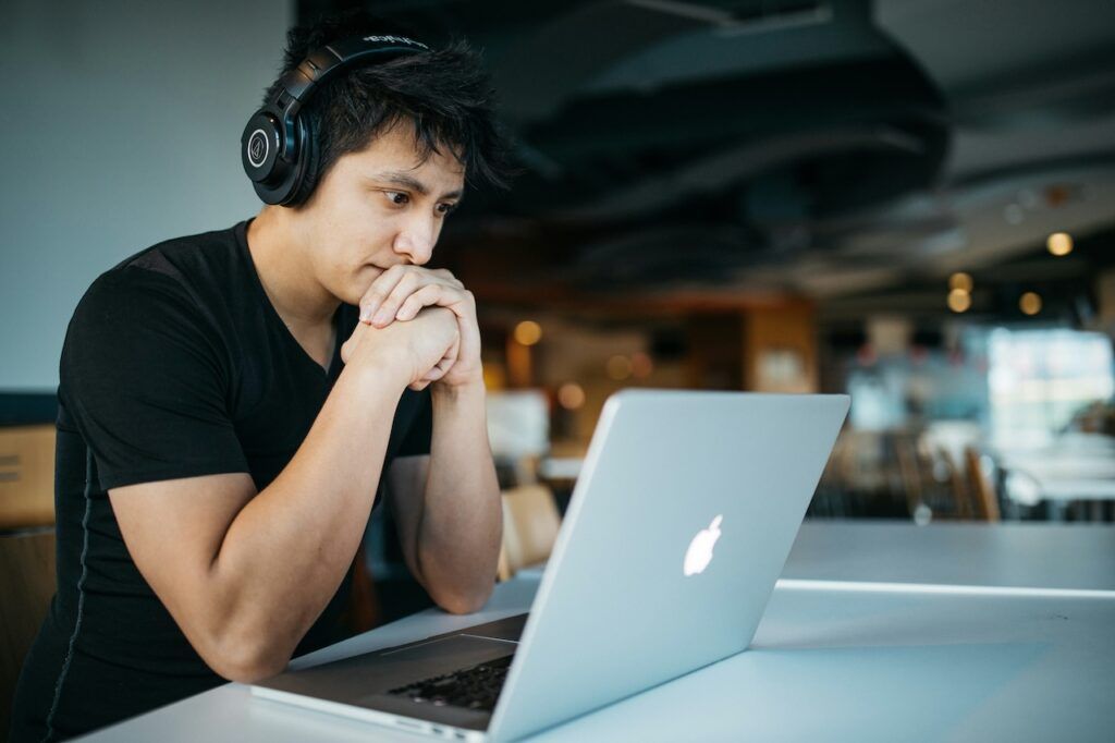 Man wearing headphones working on laptop